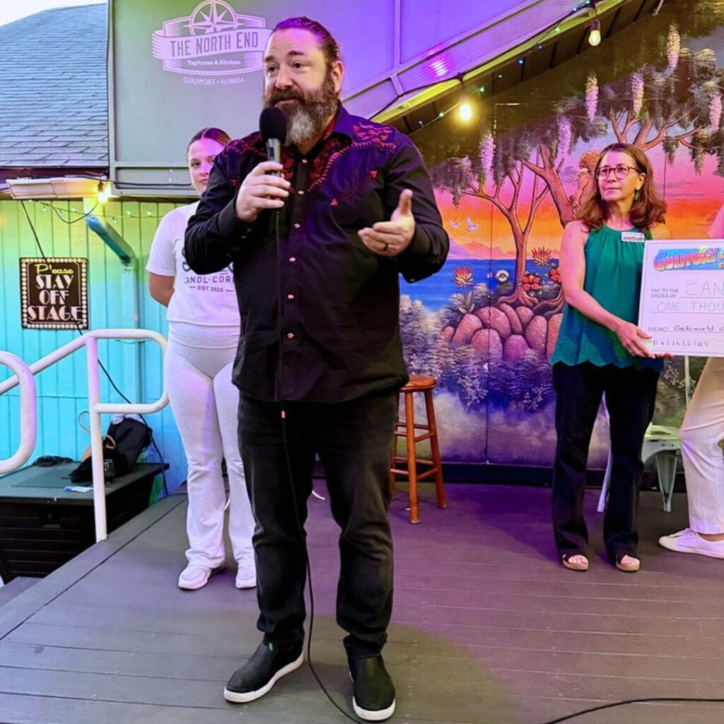 CANDL Corp representative accepts a Gecko World Grant from the Gulfport Merchants Chamber during a community event in Gulfport, Florida