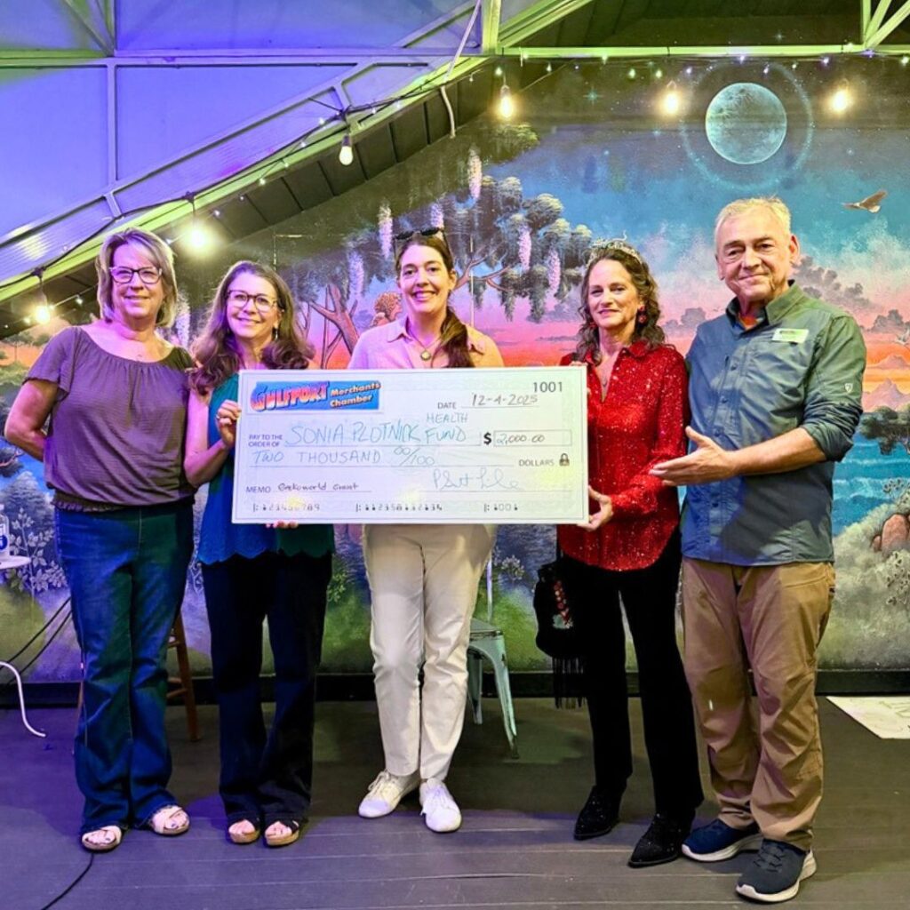 Gulfport Merchants Chamber board members present a Gecko World Grant check to the Sonia Plotnick Foundation at a community event in Gulfport, Florida